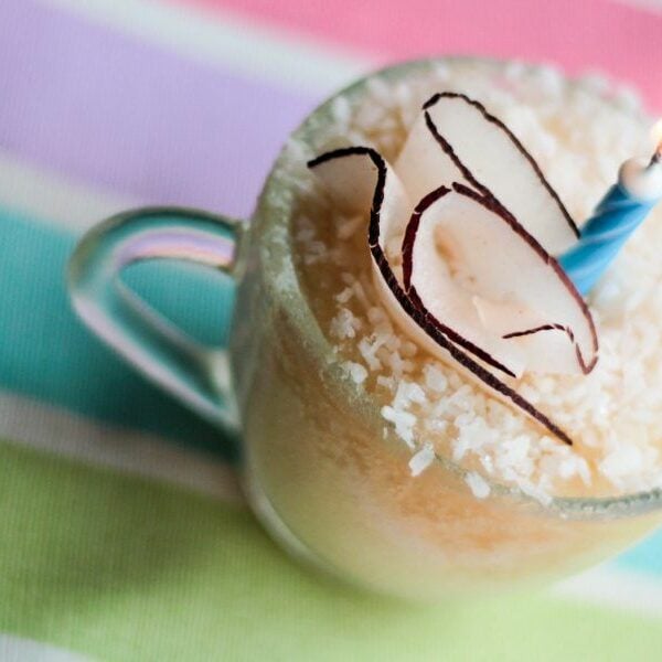 A dainty vanilla mug cake with a candle on top.